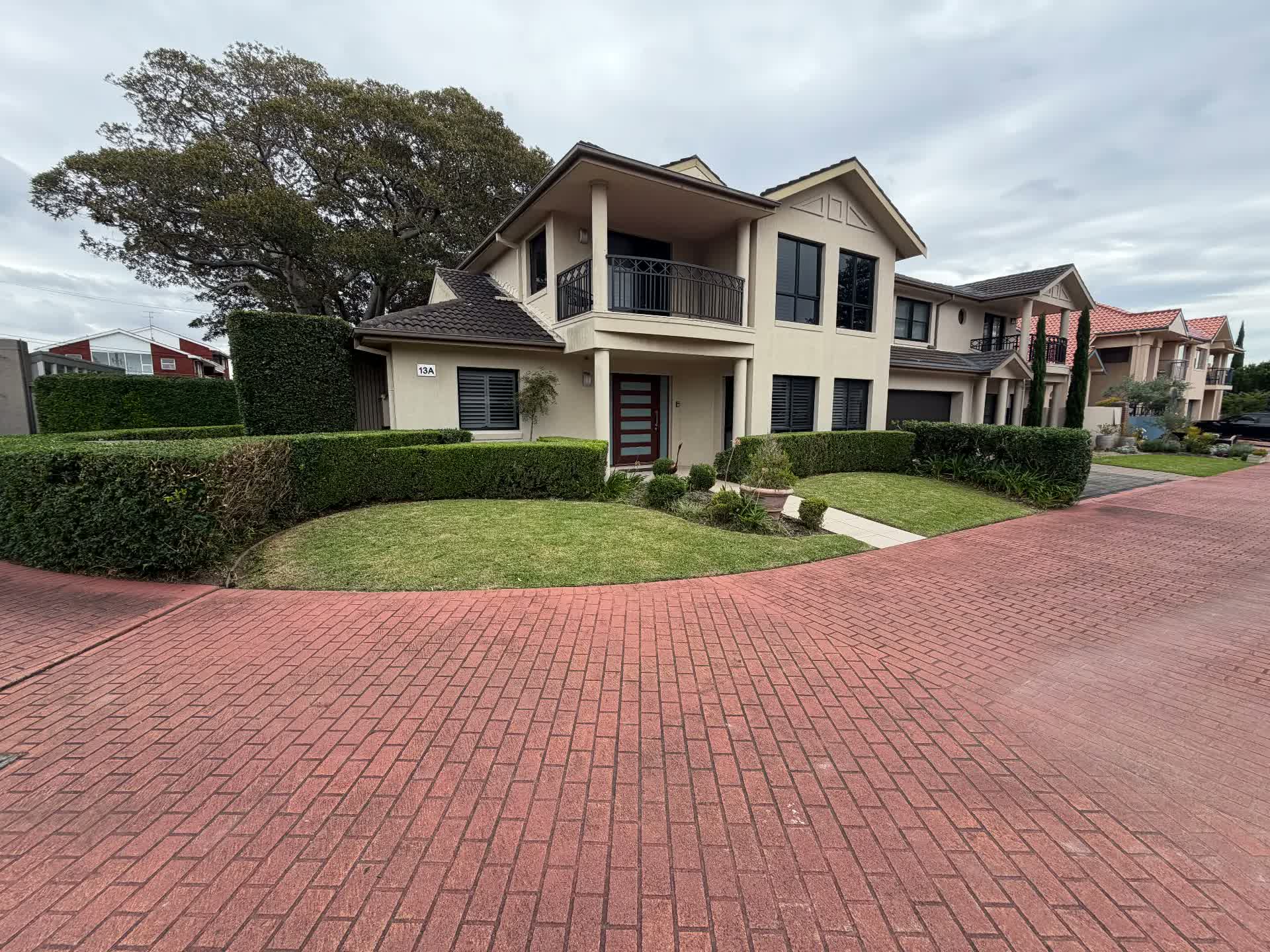 Clipped front hedges and lawn edges at a townhouse entry